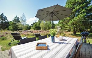 a table with an umbrella on a patio at Holiday Home Præstekraven Rømø in Rømø Kirkeby