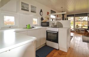 a kitchen with white cabinets and a stove top oven at Holiday Home Rylevej Ørsted Denm in Kare