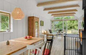een keuken met een tafel en stoelen en een eetkamer bij Beach Front Home In Strby With Kitchen in Strøby