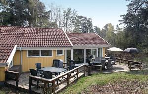 a house with a deck with tables and chairs at 4 Bedroom Lovely Home In Nex in Snogebæk