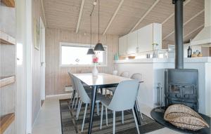 a kitchen and dining room with a table and chairs at Cozy Home In Hjrring With House Sea View in Lønstrup