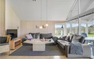 a living room with a couch and a table at Awesome Home In Otterup With Sauna in Hasmark