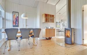 バイアス・スタンにあるBeautiful Home In Vejers Strand With 3 Bedrooms, Sauna And Wifiのダイニングルーム(テーブル、椅子、暖炉付)