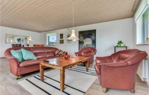 a living room with leather furniture and a wooden table at Lovely Home In Lgumkloster With House A Panoramic View in Agerskov