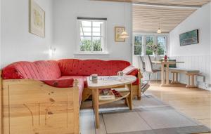 ein Wohnzimmer mit einem roten Sofa und einem Tisch in der Unterkunft Joe in Rønne