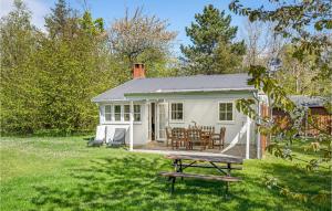 ein weißes Cottage mit einem Picknicktisch im Hof in der Unterkunft Joe in Rønne