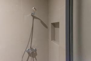 a shower with a shower head in a bathroom at TwoSpaces Living at Kencana Residence in Gunungsan