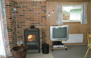 un salon avec une télévision et une cheminée dans l'établissement Stunning Home In Humble With Sauna, à Humble