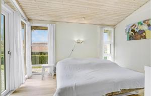 een witte slaapkamer met een bed en een raam bij Cozy Home In Haarby With House Sea View in Brydegård