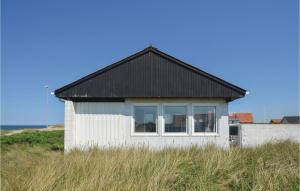 FrøstrupにあるAmazing Home In Frstrup With 3 Bedrooms And Wifiの黒屋根の小さな白い家
