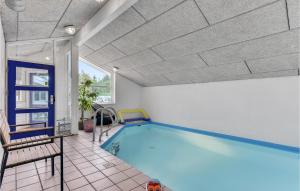 a swimming pool in a room with a tile floor at Beautiful Home In Juelsminde With 4 Bedrooms, Wifi And Indoor Swimming Pool in Sønderby