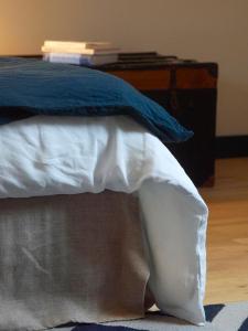 a bed with white sheets and blue pillows on it at La vigie d'Héloïse, appartement de l'Aod in Ouessant