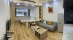 Shenzhen Duowei Luxury Apartment Chegongmiao Branch في شنجن: غرفة معيشة مع أريكة وطاولة