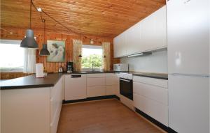 cocina con armarios blancos y techo de madera en Pej, en Fanø 5 fotos más
