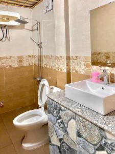 bagno con servizi igienici bianchi e lavandino di Bamboo Hill Villa a Ninh Binh