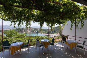 eine Terrasse mit Tischen und Stühlen und Seeblick in der Unterkunft Guest House Oreb in Koločep