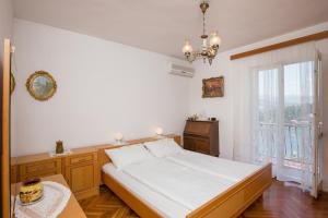 a bedroom with a bed and a large window at Guest House Oreb in Koločep