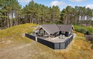 a small house on a hill with a deck at Stunning Home In Rm With 3 Bedrooms, Sauna And Wifi in Rømø Kirkeby