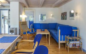 ein Wohnzimmer mit einem blauen Sofa und Stühlen in der Unterkunft Beautiful Home In Nexø With Sauna in Neksø
