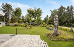 einen Garten mit einem Holzsteg und einer Statue in der Unterkunft Stunning Home In Glesborg With Wifi in Glesborg