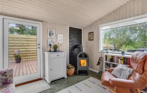 - un salon avec un poêle à bois et une chaise dans l'établissement 2 Bedroom Amazing Home In Sydals, à Østerby