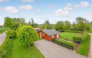une maison rouge avec une clôture dans une cour dans l'établissement 2 Bedroom Amazing Home In Sydals, à Østerby