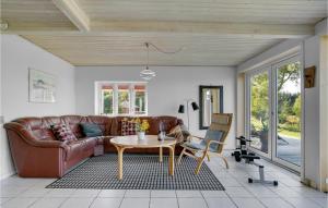 a living room with a leather couch and a table at Pet Friendly Home In Christiansfeld With Sauna in Christiansfeld