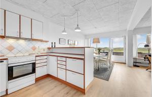 a kitchen with white cabinets and a dining room at Two-Bedroom Apartment Nørre Nebel With Sea View 04 in Nymindegab +18 photos
