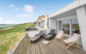 a deck with two chairs and an umbrella at Beautiful Apartment In Nrre Nebel With 2 Bedrooms And Wifi in Nymindegab