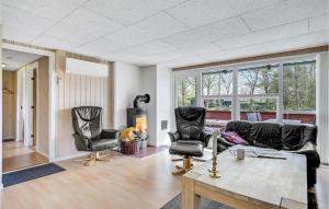 a living room with two chairs and a table at Holiday Home Fyrrevænget Blåvand X in Ho