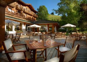 a dining room table with chairs and a patio at Hotel Beauregard in La Clusaz