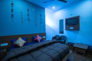 Sai Ganga Cottage by Hotel B Grand في ريشيكيش: غرفة نوم زرقاء مع سرير وتلفزيون