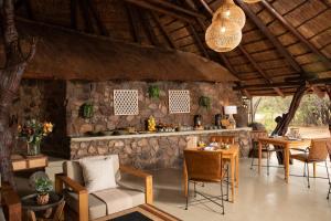 a room with tables and chairs and a stone wall at Kwafubesi Tented Safari Camp in Mabula