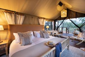 1 dormitorio con 1 cama grande en una tienda de campaña en Kwafubesi Tented Safari Camp, en Mabula