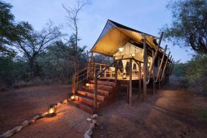 a tent with stairs and lights in a field at Kwafubesi Tented Safari Camp in Mabula