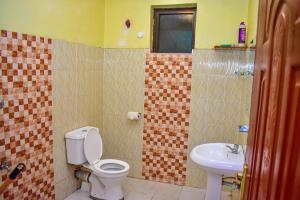 a bathroom with a toilet and a sink at Unique, Stylish Studio Apartment in Kisumu