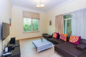 a living room with a couch and a tv at Spacious 3 Bed Room Apartment - Palm Jumeirah Dubai in Dubai