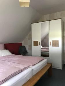 a bedroom with a large bed and a cabinet at Haus Eierhof in Papenburg