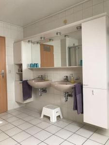 a bathroom with two sinks and a stool in it at Haus Eierhof in Papenburg