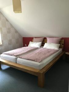 een bed met roze lakens en kussens in een kamer bij Haus Eierhof in Papenburg