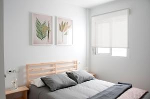 um quarto com uma cama e duas fotografias na parede em Felipe Antón Suites em Mutxamel