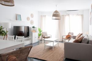 uma sala de estar com um sofá e uma televisão em Felipe Antón Suites em Mutxamel