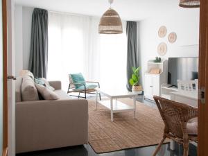 uma sala de estar com um sofá e uma mesa em Felipe Antón Suites em Mutxamel