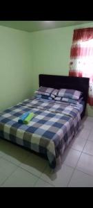 a bed in a room with a checkered at MAK Homstay upstairs in Kundasang