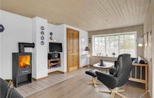a living room with a fireplace and a chair at Lovely Home In Rm With Kitchen in Bolilmark