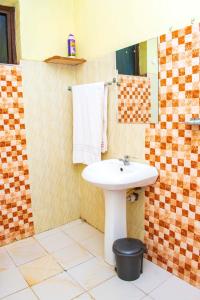 a bathroom with a sink and a mirror at Unique, Stylish Studio Apartment in Kisumu