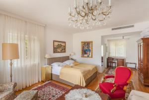 Un dormitorio con una cama, una silla y una lámpara de araña. en Hotel Triglav, en Bled