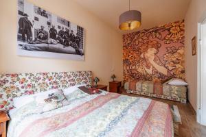 - une chambre avec un lit et une peinture murale dans l'établissement Altwienerhof Aparthotel, à Vienne