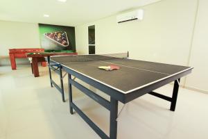 a ping pong table with a ping pong racket on it at Sun Residence in Fortaleza