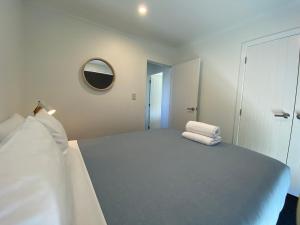 a white room with a bed and a mirror at Townhouse Feel in Irishman in Twizel